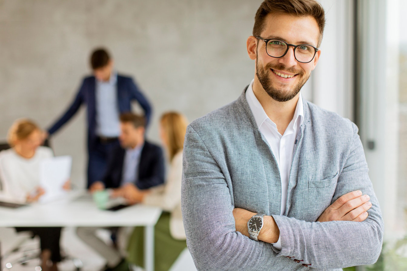 Handsome Young Business Man Standing Confident in the Office